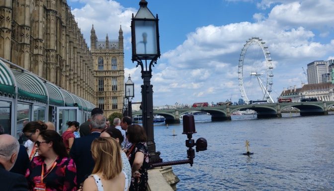 Guests on the terrace at the Houses of Parliament, which overlooks the River Thames. The London Eye is in the background.