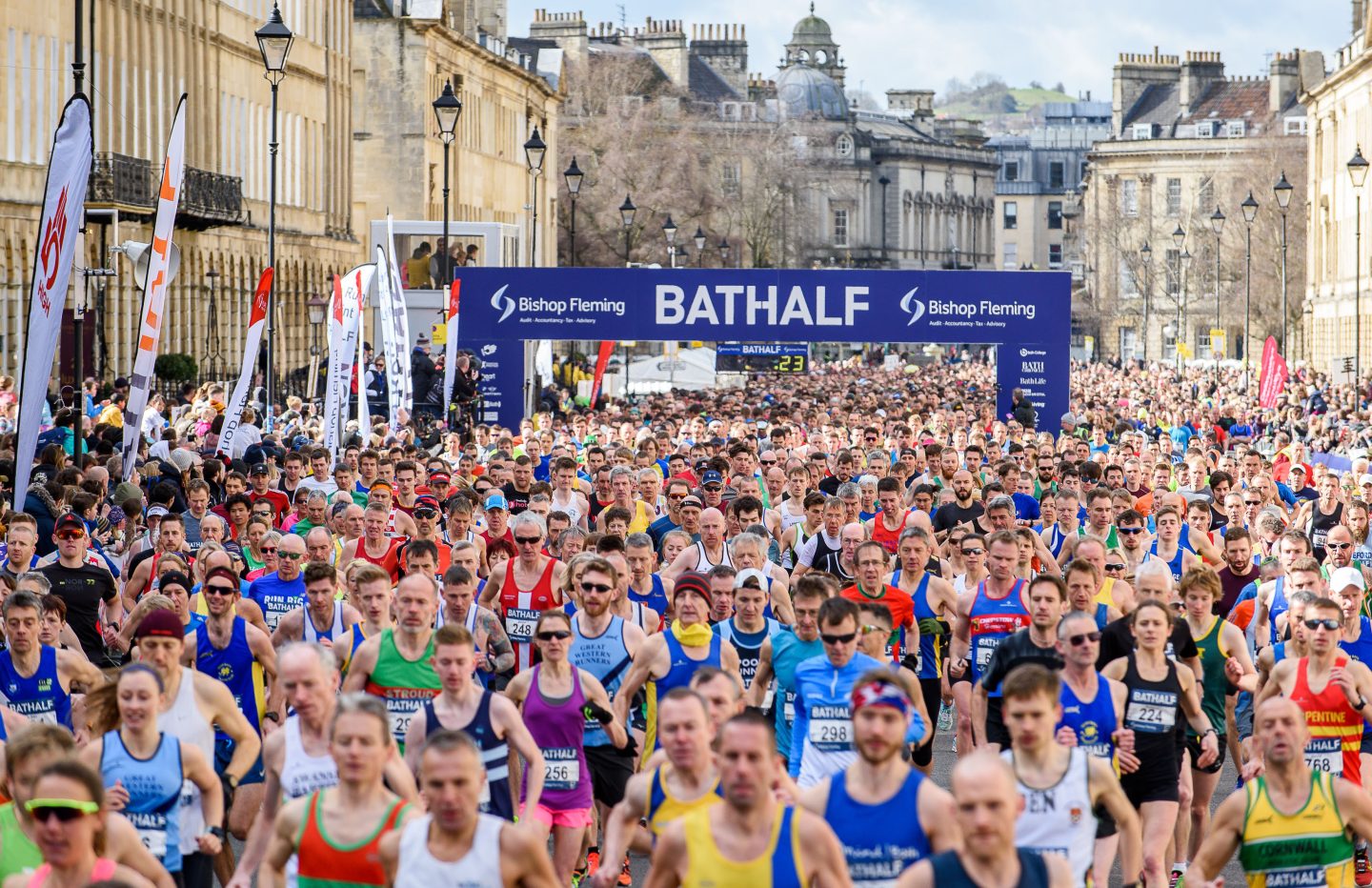The start line of the Bath Half Marathon. The street is filled with runners and spectators.