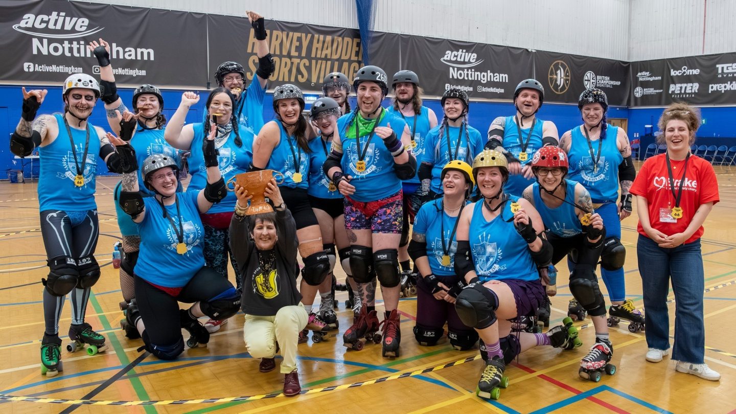 A large group of people wearing roller skates and protective gear pose for a photo.