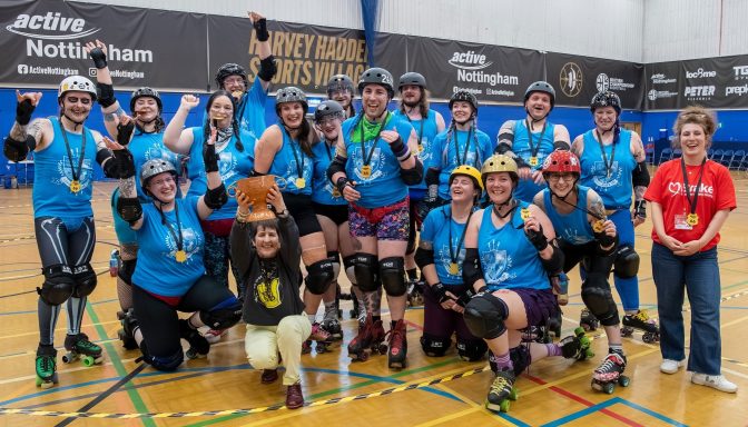 A large group of people wearing roller skates and protective gear pose for a photo.