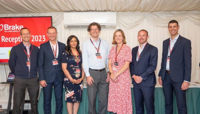 Seven smartly-dressed people smiling and posing for a photo