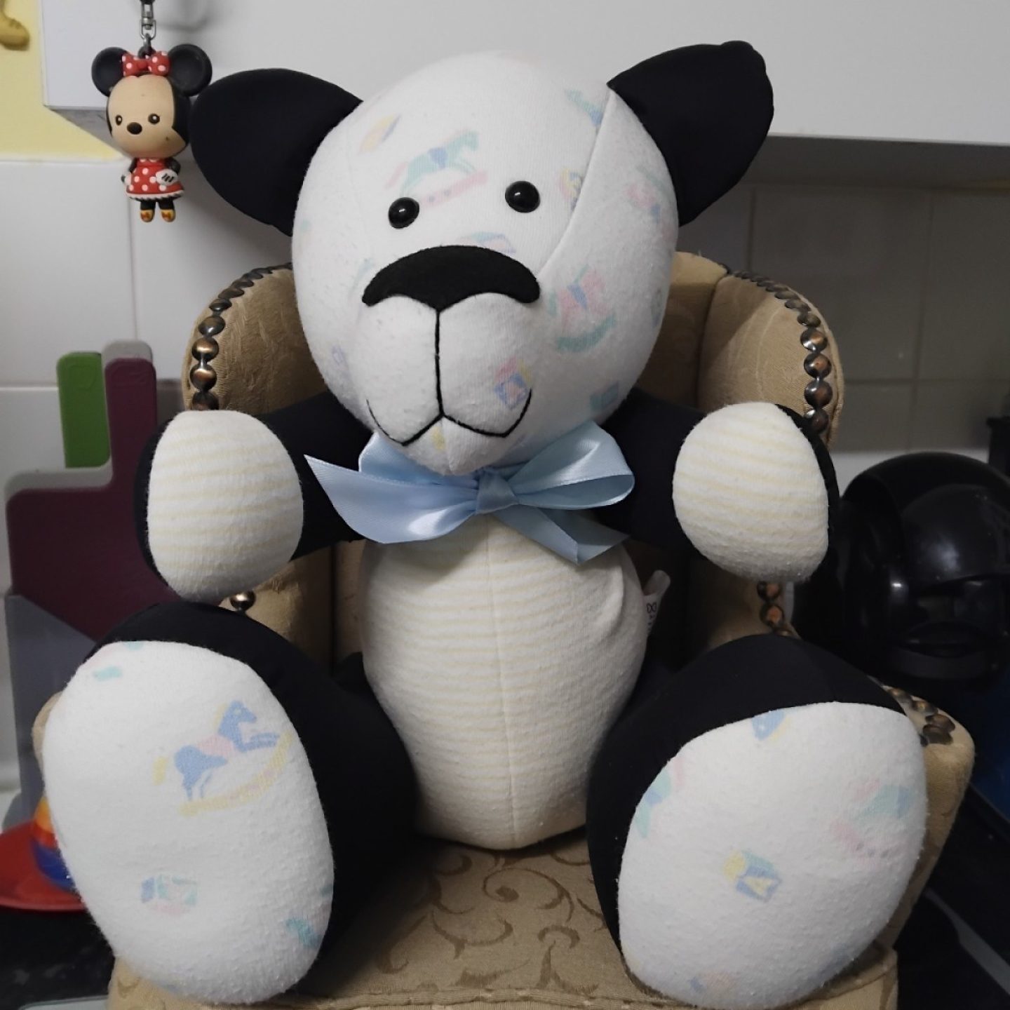 A black and white teddy bear made from clothes. It's called a memory bear, as it's made from loved ones' clothing.