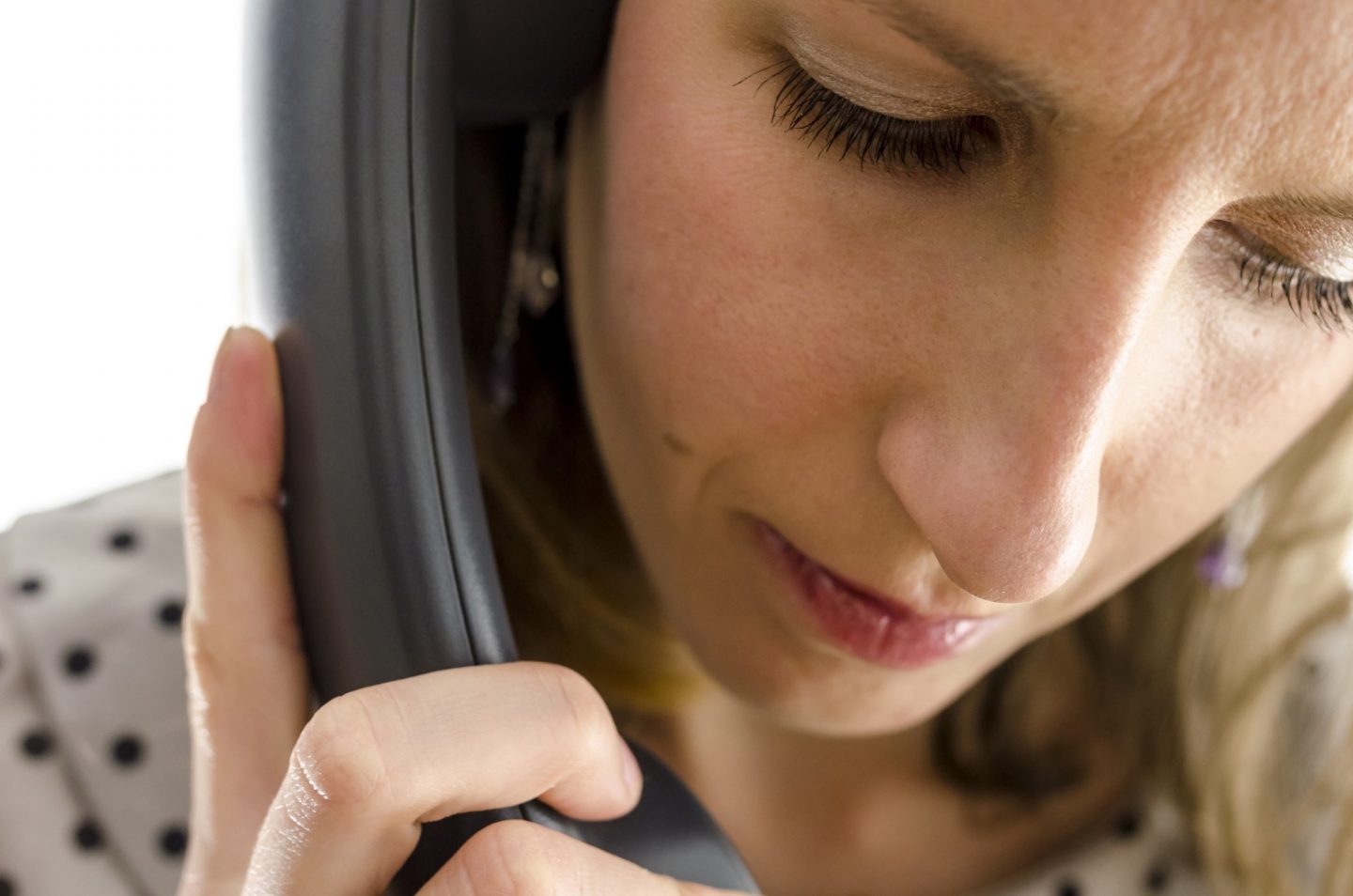 A woman talking on her phone, with a thoughtful expression on her face.