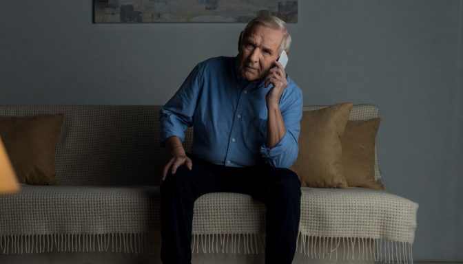 Man on sofa holding phone