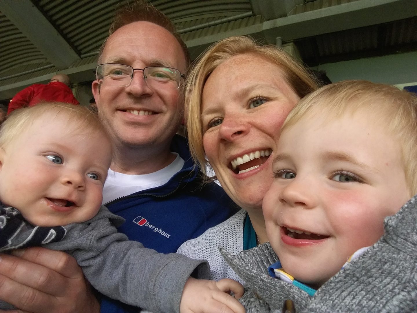 Two parents and their young sons pose for a photograph.